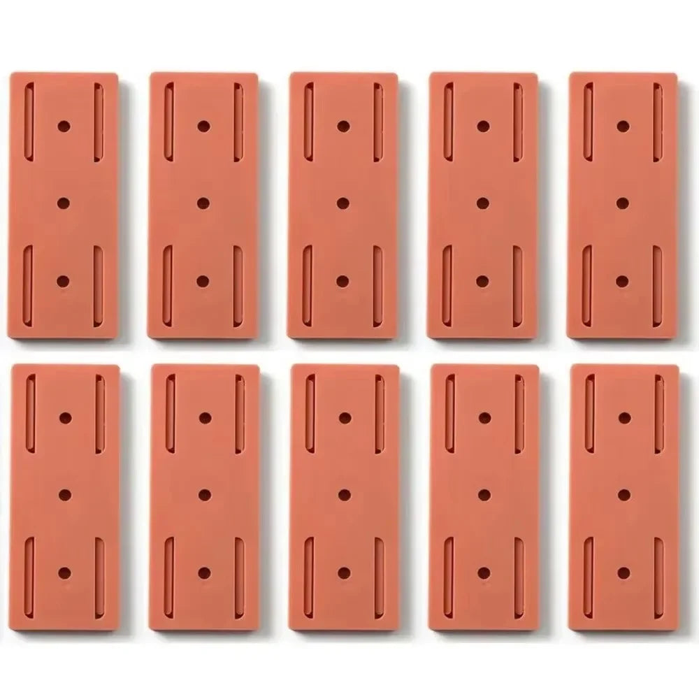 Set of 10 Smartlyo self-adhesive socket holders mounted on a wall for organizing electrical sockets.